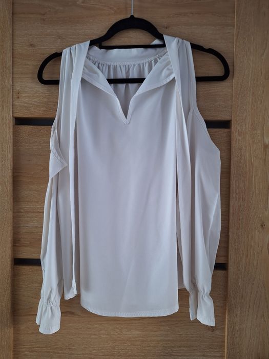 Biała bluzka z wycięciem na ramiona i ozdobnym wiązaniem na tyle