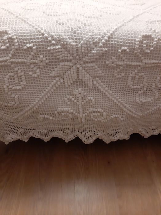 Colcha branca de renda feita à  mão .
