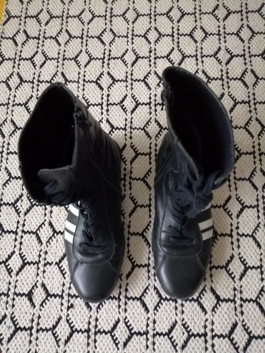 Botas pretas de engraxar com riscas brancas