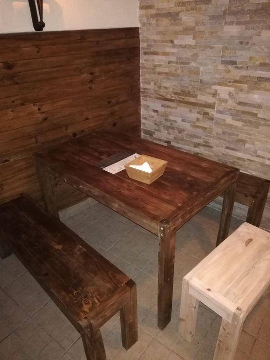 Vários tipos de mesas e bancos de madeira rústica e muito robusta.