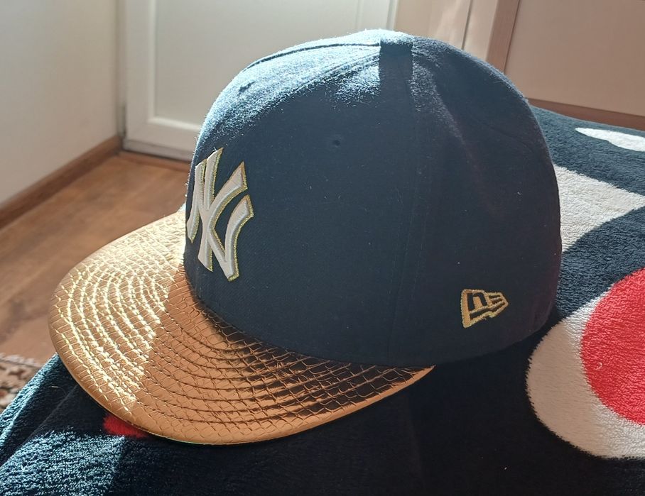 Синя бейсболка реперка New Era з золотим козирком та логотипом New York Yankees.