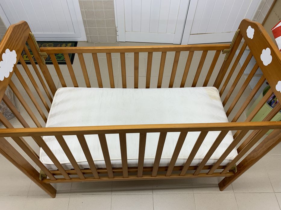 Berço em madeira maciça com grade que sobe e desce.