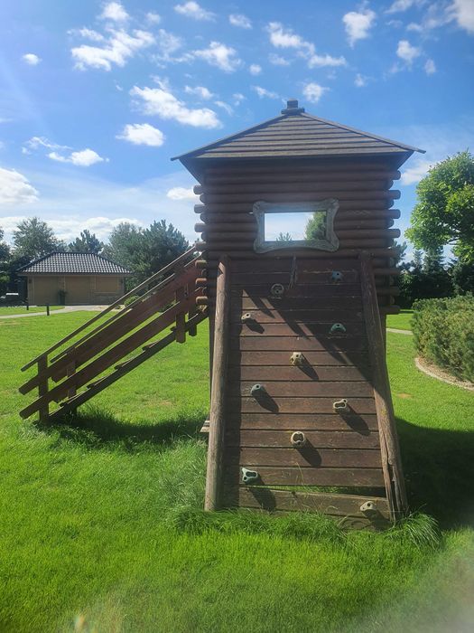 Drewniany domek ogrodowy ze zjeżdżalnią dla dzieci