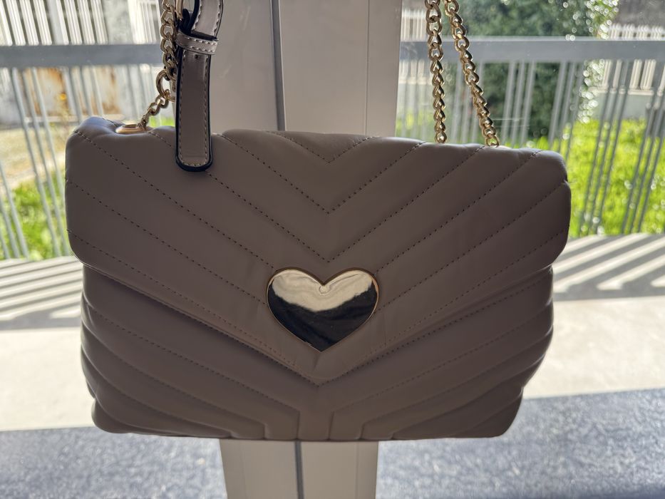 Mala bege com detalhe dourado em coração