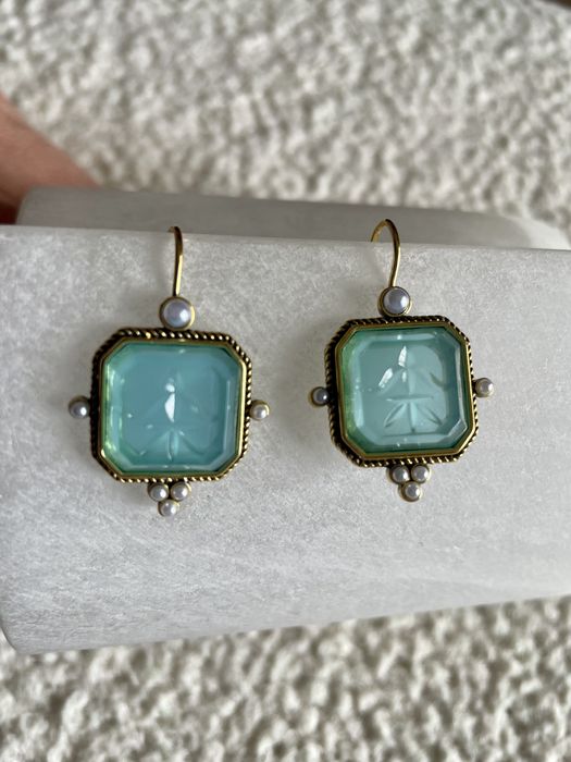Brincos em metal dourado com cristal turquesa