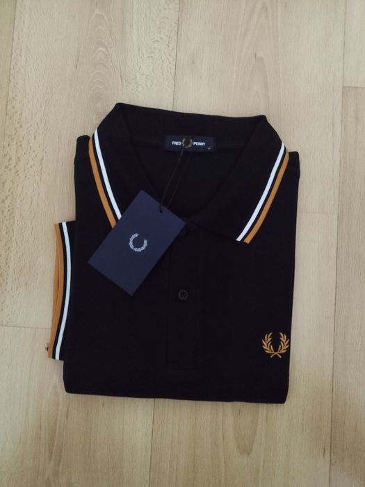 Pólo Fred Perry preto com listas brancas e amarelas.