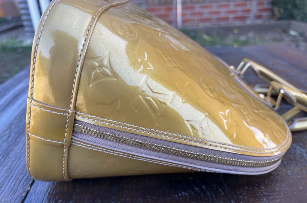 Mala  bolsa Louis Vuitton Alma PM dourada