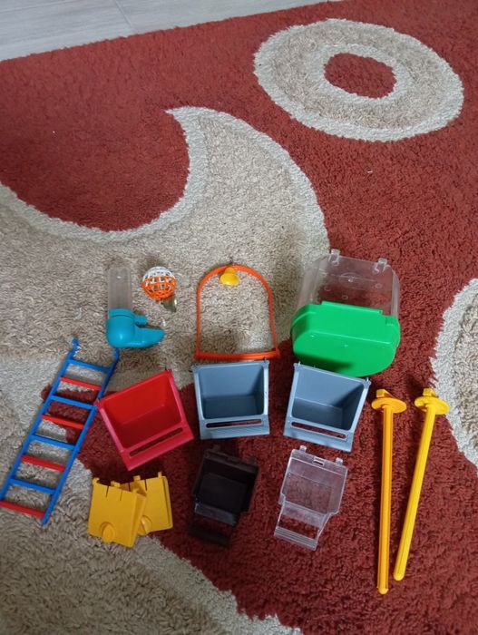 велика клітка для папуги з мисочками і іграшками