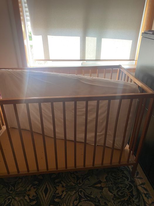 Cama de grades em madeira natural com colchão e resguardo