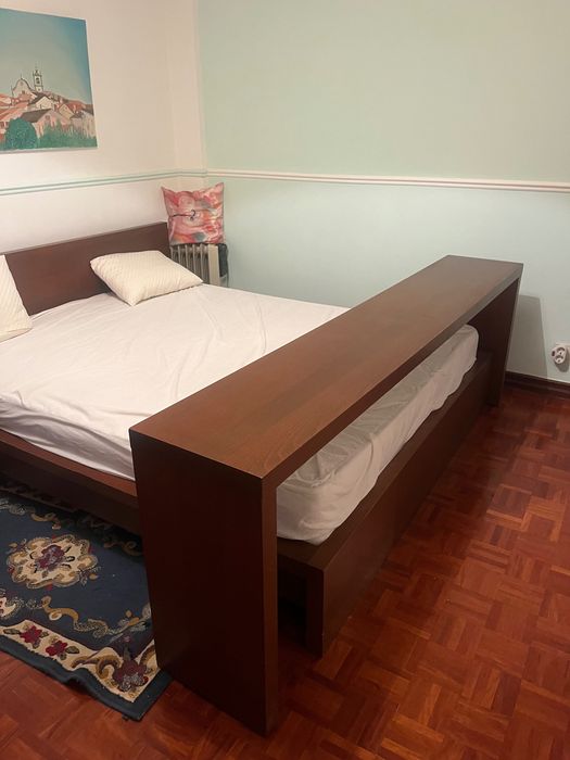 Cama de casal com mesa de cabeceira e apoio