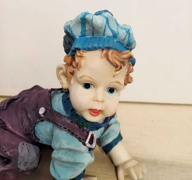Estatuetas meninos a gatinhar