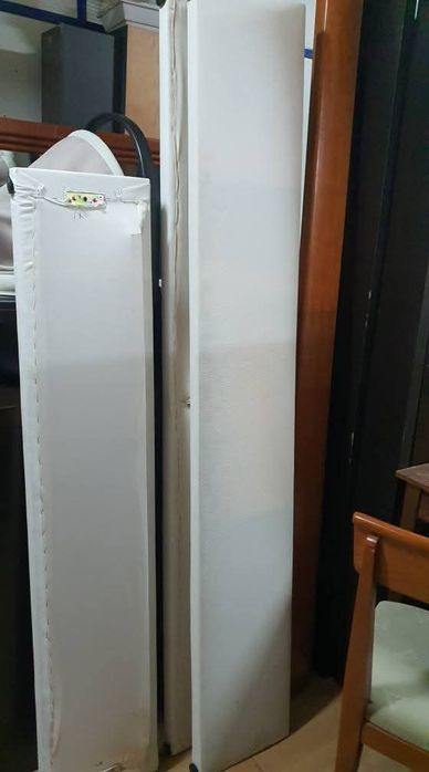 Cama estofada e mesinhas com marcas de uso estrado