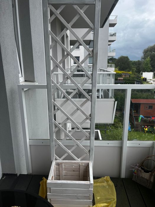 Biała drewniana pergola z donicą