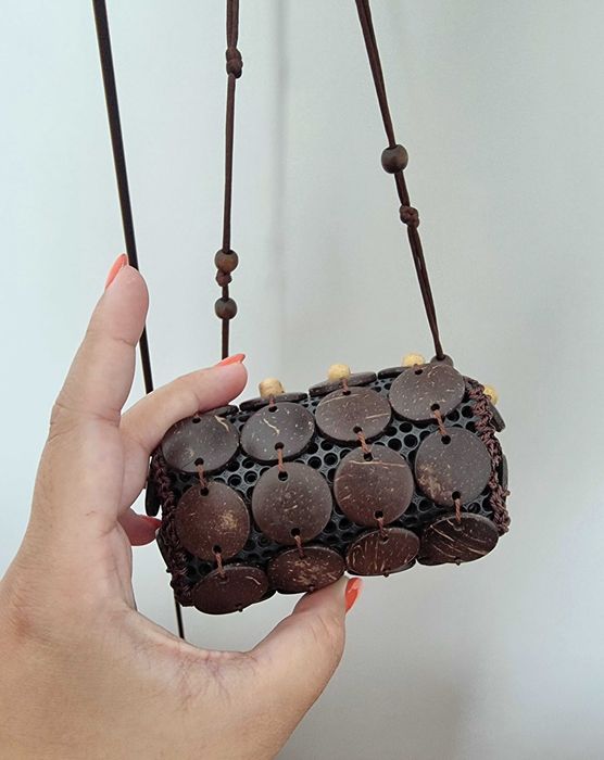 Mala pequena castanha com detalhes e uma flor