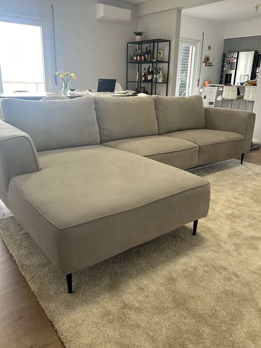 Sofá chaise long cinza com os pés pretos