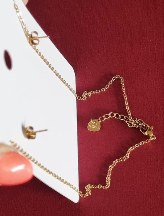 Conjunto dourado, em aço, com corações de Viana em tons de azul.