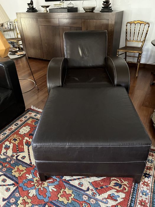 Poltrona e puff em pele castanha e pespontos brancos