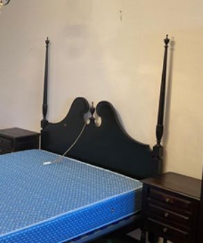 Cama de casal com duas mesas de cabeceira em castanho.