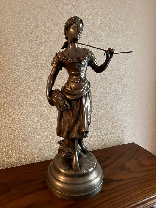 Estatueta feminina metálica