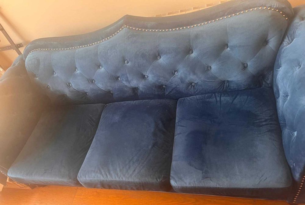Sofá azul de veludo com três lugares