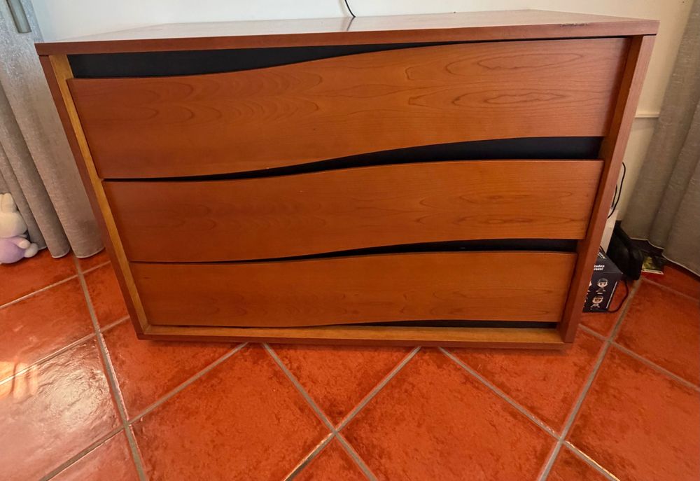 Uma cama com 2 mesinhas de cabeceiras e uma cómoda