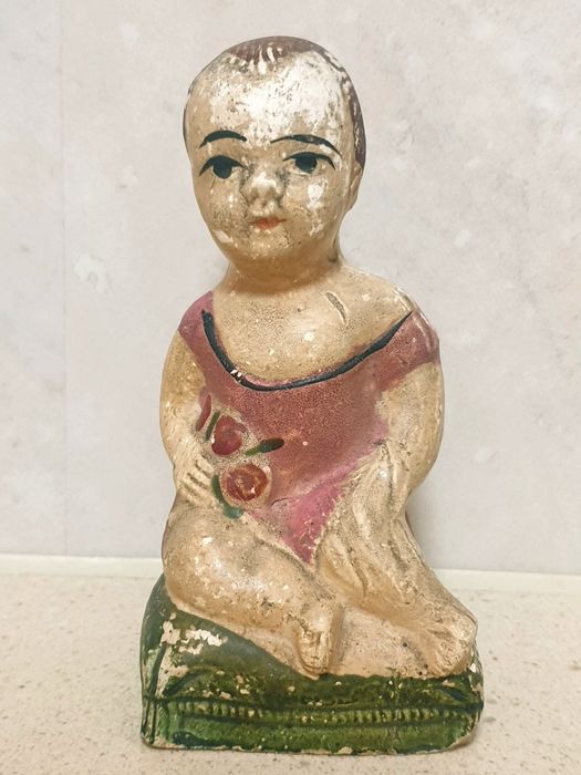 Antiga escultura de uma criança com rosas em cerâmica