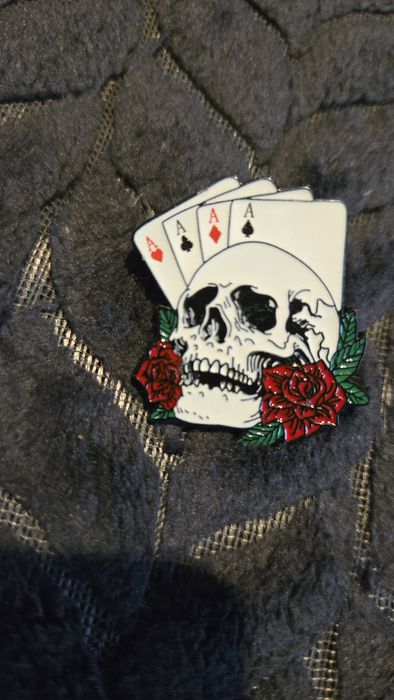 Przypinka karty i czaszka.