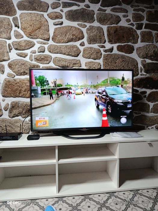 Um sofá cama, três Tvs e um refrigerador.