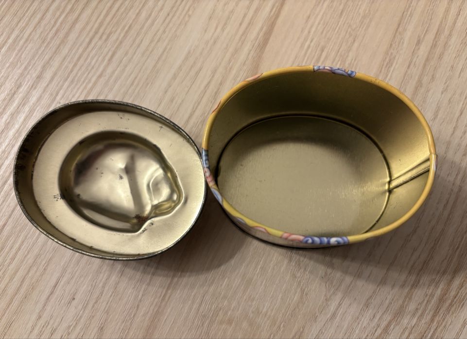 Caixa de lata oval, com gato em relevo