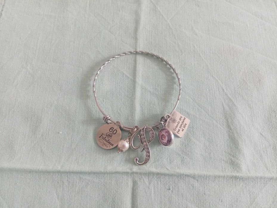 Pulseira em aço inoxidável, com vários berloques temáticos (charm bracelet)