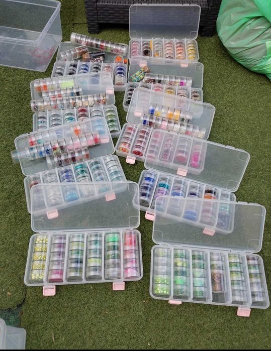 Conjunto de caixas com missangas de várias cores e tamanhos.