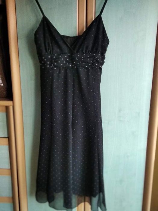 Czarna sukienka w białe groszki na cienkich ramiączkach.