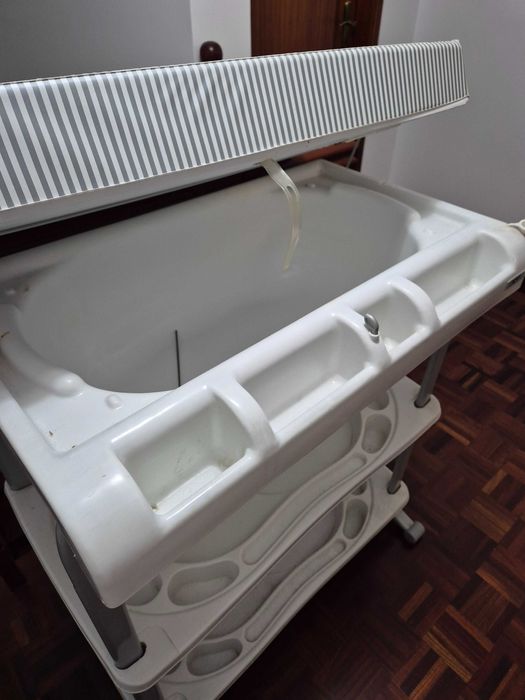 Fraldário com banheira e com espaço de arrumação.