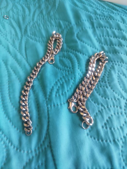 2 pulseiras em aço inox, novas, com 18,5cm de comprimento, 1,2cm de largura, 3,5cm de espessura. Contém 4 argolas e fechos mosquetão suplentes.