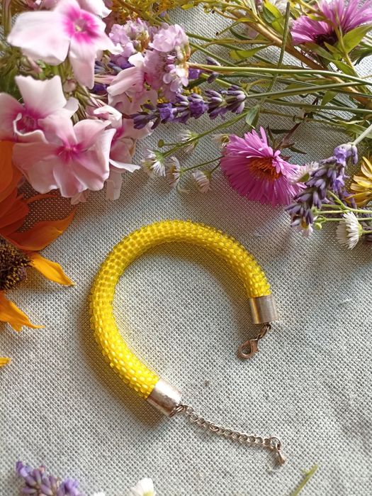 Żółta bransoletka zrobiona na szydełku.