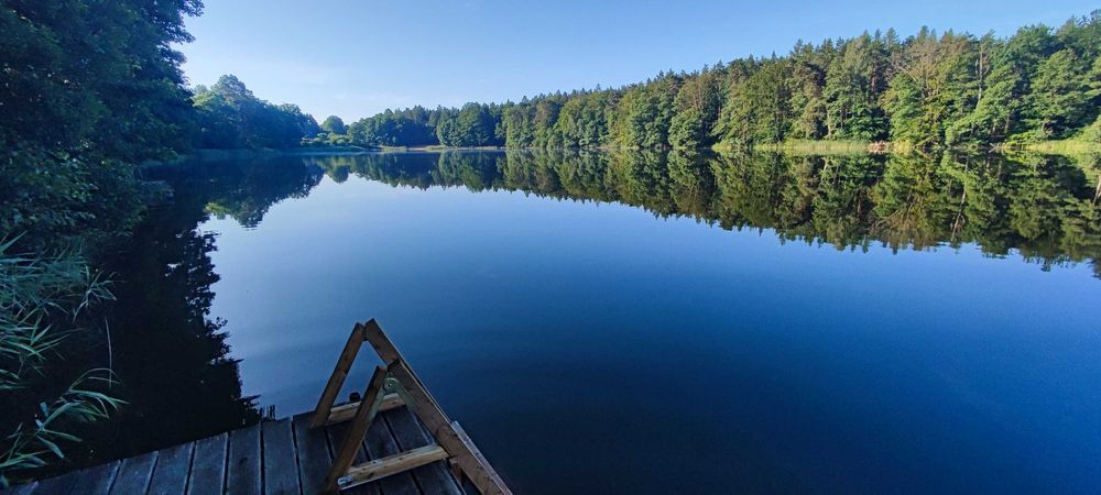 Domek nad jeziorem z linią brzegową i pomostem. Puszcza Barlinecka.