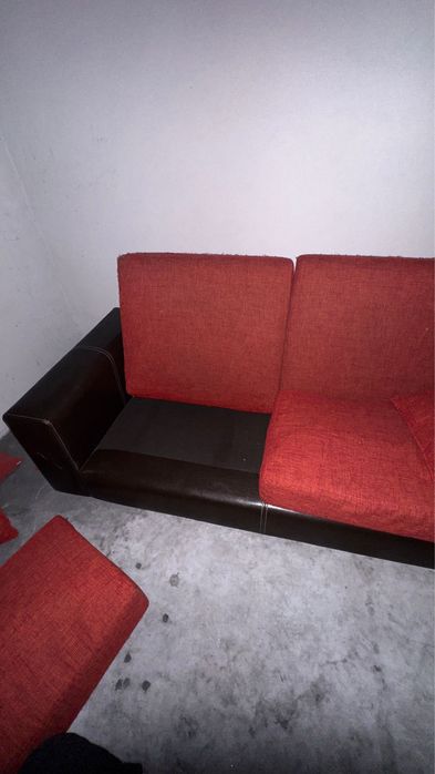 Sofá castanho em pele, com encostos e assentos em almofadas,.