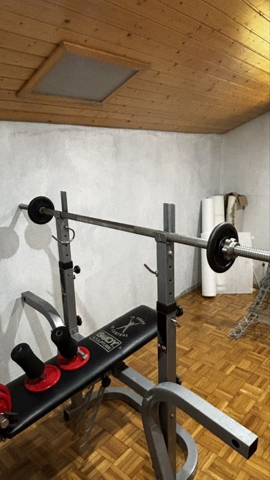 Banco de musculação com suporte para barra + halteres.