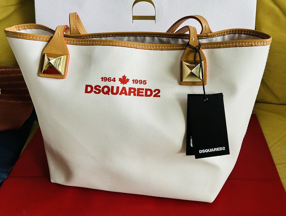 Pojemna torebka shopper  ecru marki Dsquared2 z czerwonym haftem logo i charakterystycznymi złotymi ćwiekami.