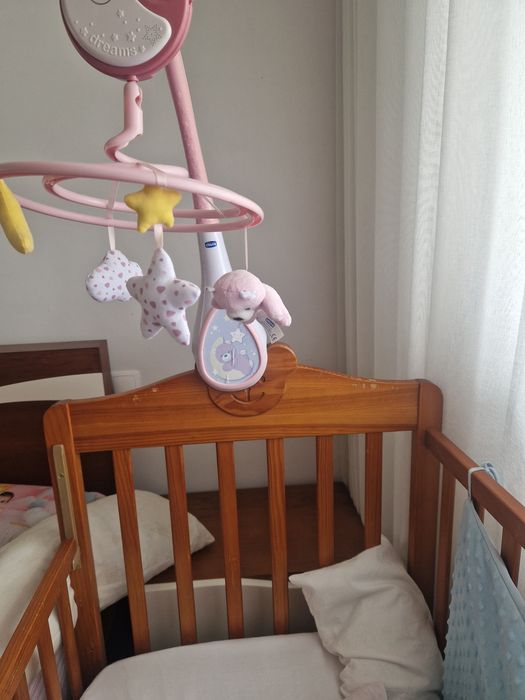 Berço com roupa de cama e mobile.