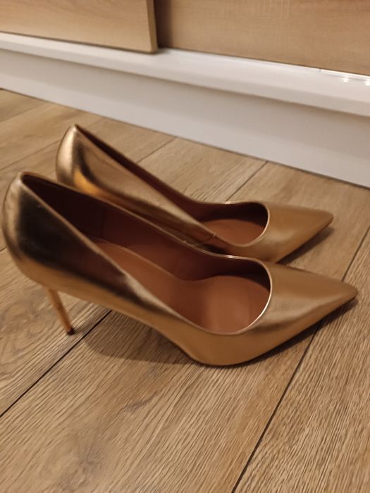 Złote wysokie szpilki