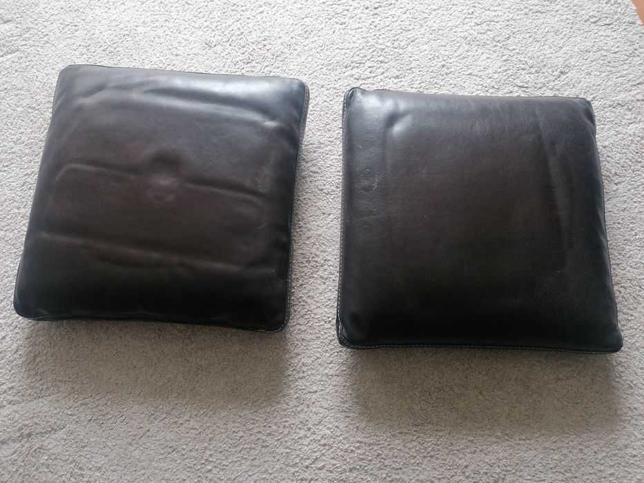 Almofadas em pele castanha com pesponto a branco