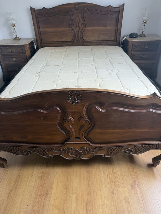 Cama de madeira macica e duas mesas de cabeceira