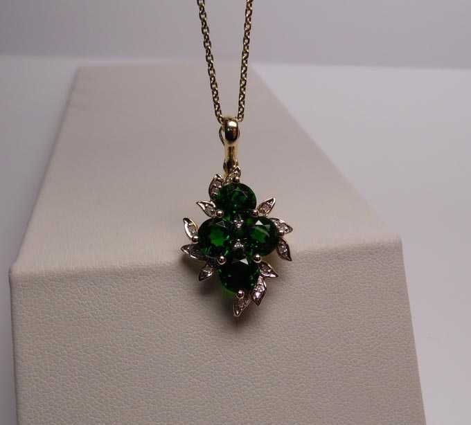 Złota zawieszka zielone diopsydy chromowe i diamenty.