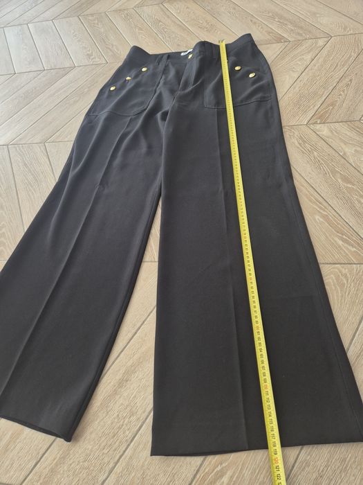 Czarne eleganckie spodnie damskie z szeroką nogawką i rzędowymi guzika