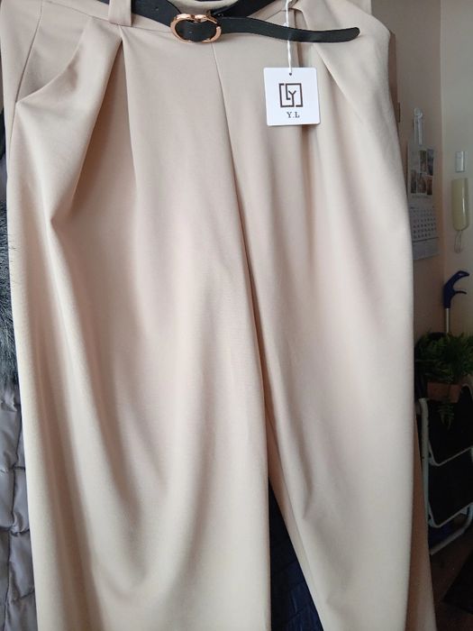 Spodnie beżowe typu szwedy z paskiem i ozdobna klamerka