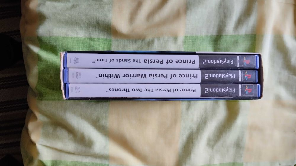 PlayStation 2 com dois jogos clássicos e dois comandos