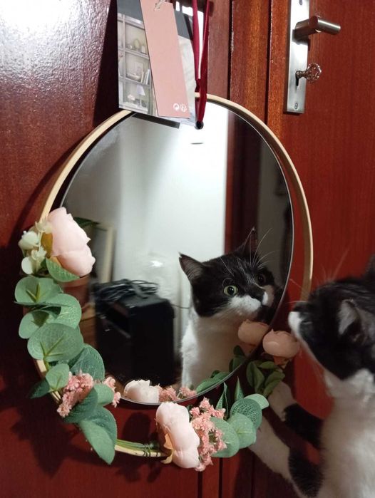 Espelho Atmosphera, aro em madeira clara, rosas e folhas verdes.