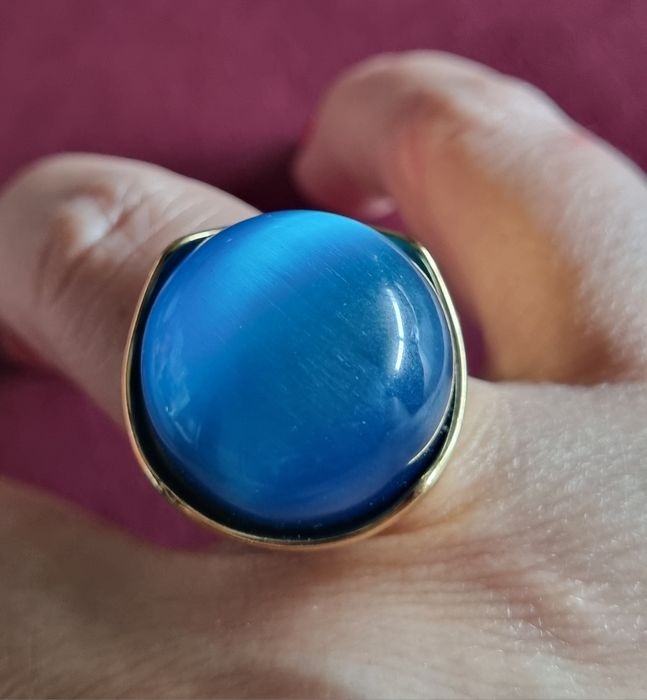 Anel dourado, em aço, com grande pedra azulão. T17