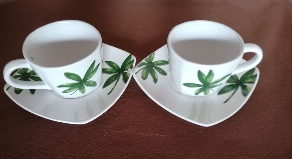 Dwie filiżanki z kwadratowymi spodkami.Wzor palemki.